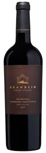 A dark glass wine bottle with a black foil cap and a brown label reading Brandlin Estate Boot Leg, Cabernet Sauvignon, 2010, Mount Veeder, 1.5L in gold text.