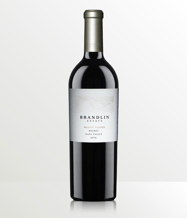 A bottle of 2019 Brandlin Estate Malbec, Mount Veeder, with a silver foil cap and white label, is shown against a light, neutral background.