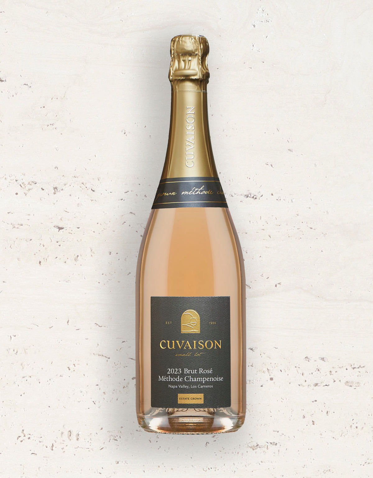 A bottle of Cuvaison 2023 Brut Rosé Champagne with a gold foil top and a black label, set against a light textured background.