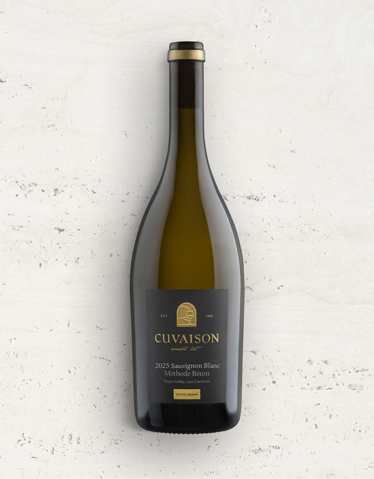 A bottle of Cuvaison 2025 Sauvignon Blanc Méthode Béton white wine, featuring a dark green glass bottle with a black label and gold lettering, set against a textured off-white background.