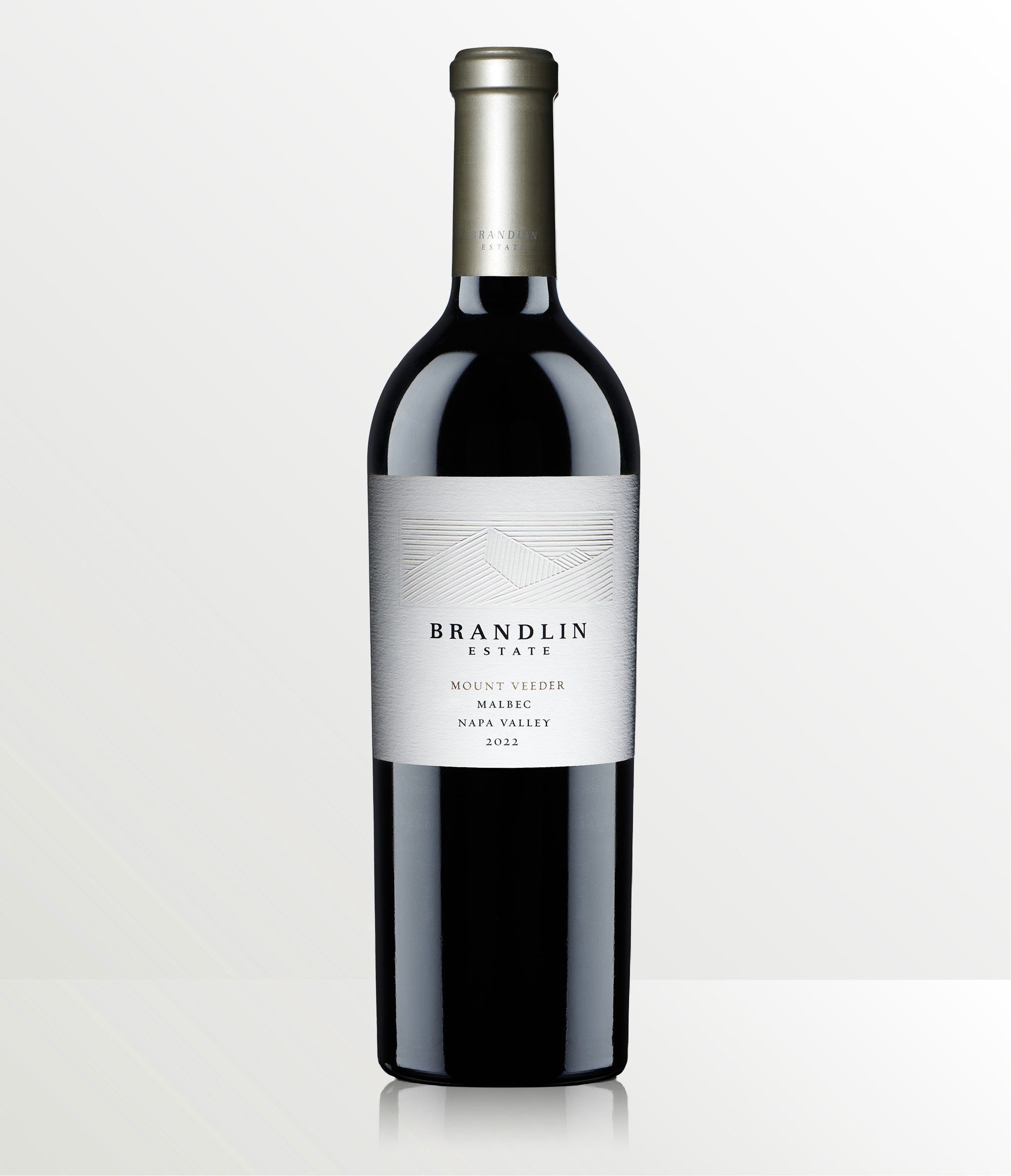 A bottle of 2022 Brandlin Estate Malbec, Mount Veeder stands upright against a light gray background. Its label is white with silver and black text featuring a simple line graphic.