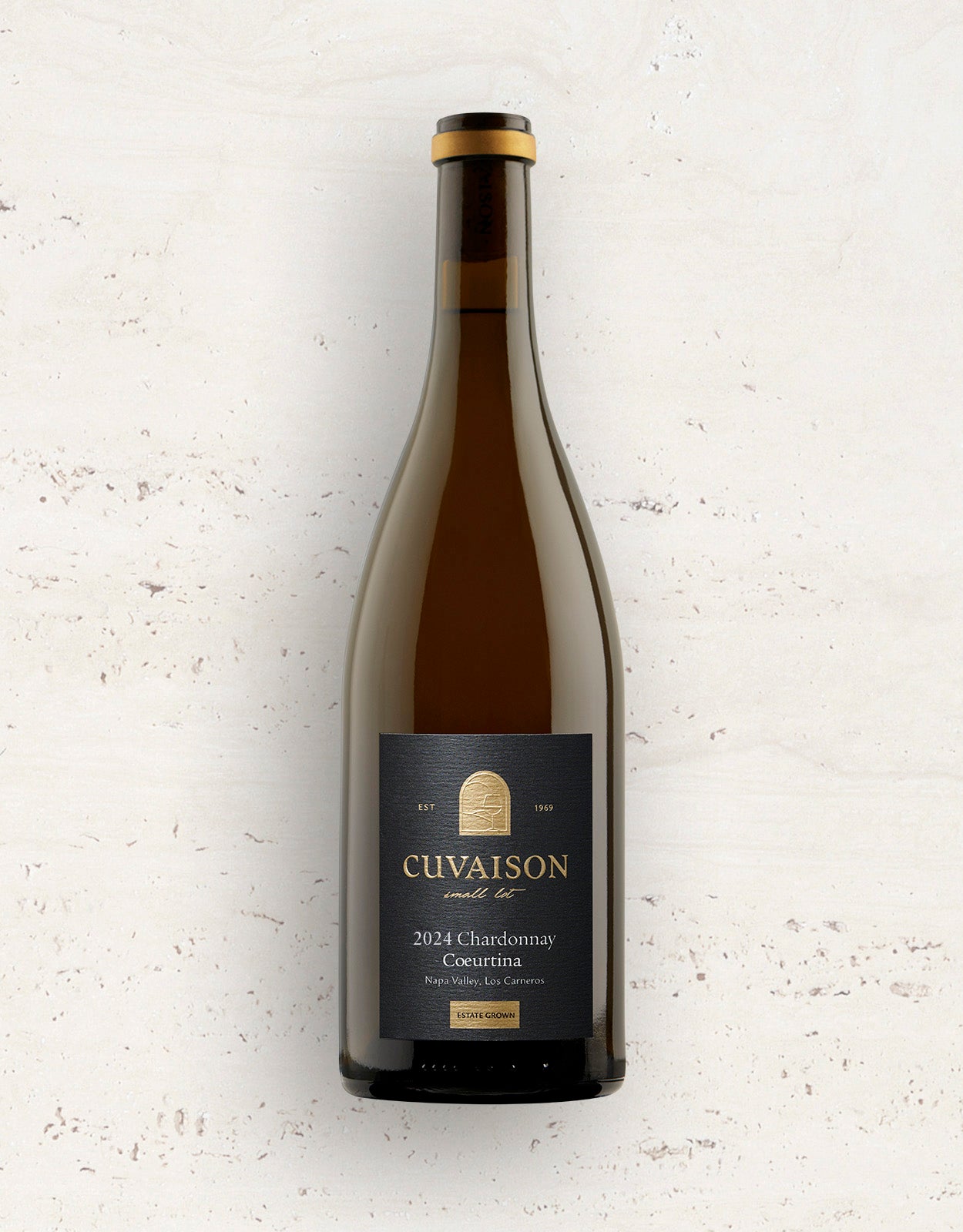 A bottle of 2024 Cuvaison Chardonnay, Coeurtina stands upright against a light textured background, its dark label displaying gold and white text with "Napa Valley, Los Carneros.