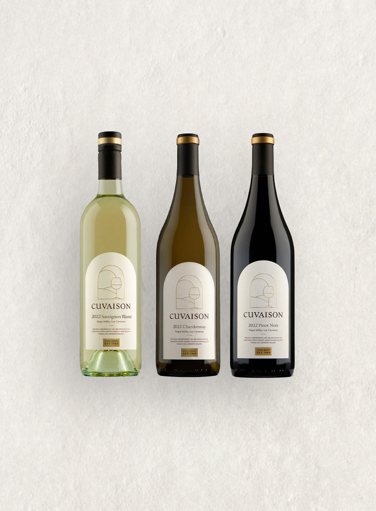 Three upright wine bottles labeled CUVAISON—Sauvignon Blanc 2022, Chardonnay 2022, and Pinot Noir 2021—are displayed on a light textured surface as the Cuvaison Classic Set.