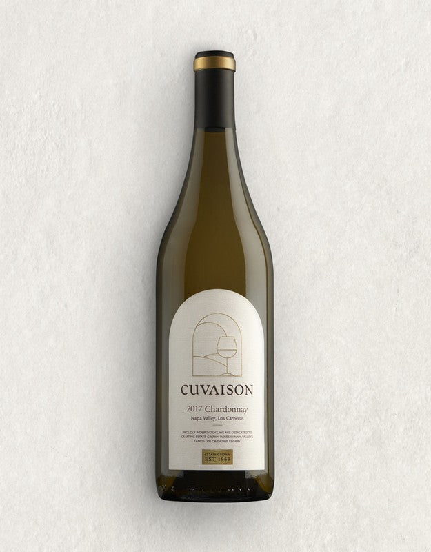 A bottle of 2017 Cuvaison Estate Chardonnay, 1.5L, stands upright on a light textured surface. The white label features gold and black text in a minimalist design.
