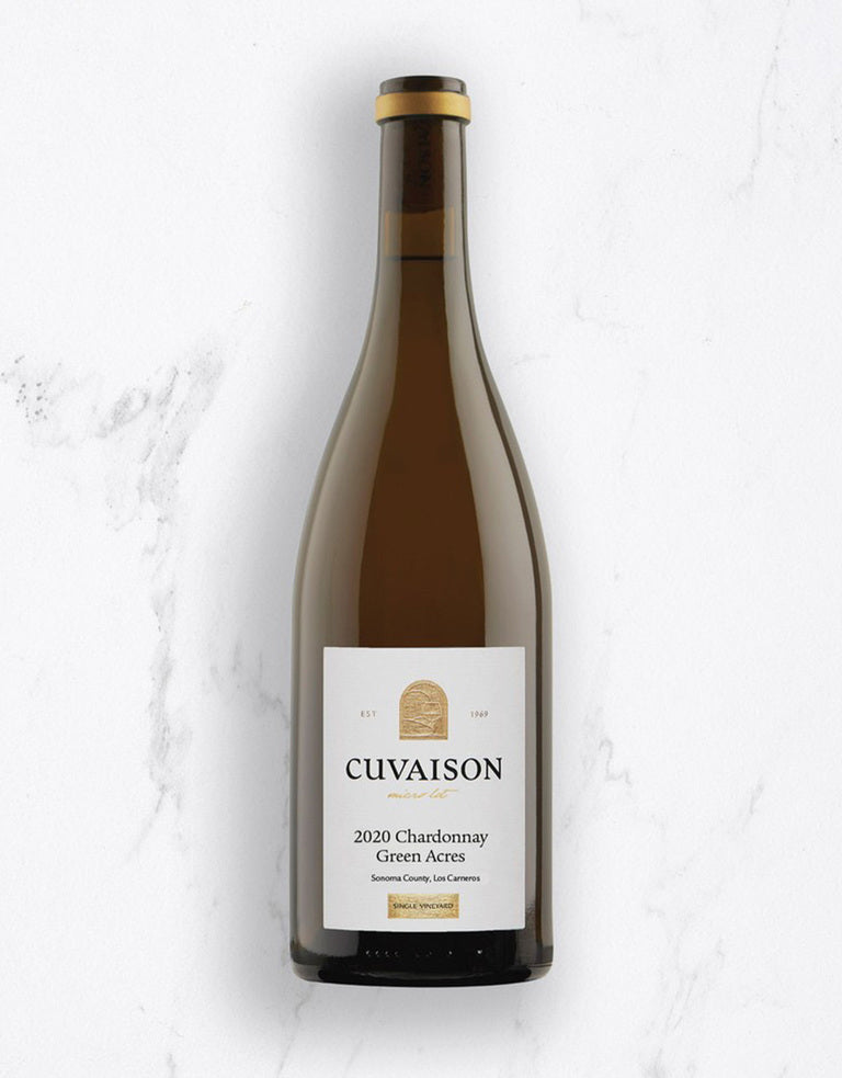 A bottle of 2020 Cuvaison Chardonnay, Green Acres stands upright on a white marble surface, featuring its label with the brand name, vintage year, and wine details in black and gold text.