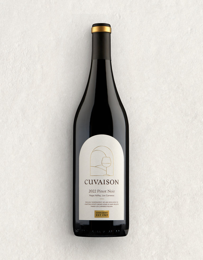 A bottle of 2022 Cuvaison Estate Pinot Noir with a beige and gold label, minimalist artwork, and wine details is displayed against a light, textured background.